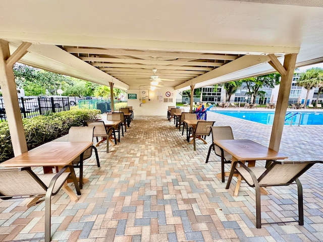 view of swimming pool with ceiling fan and a patio