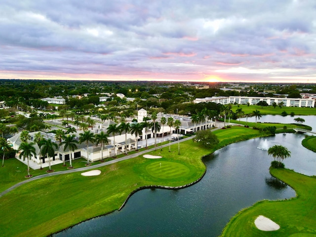 aerial view at dusk featuring a water view