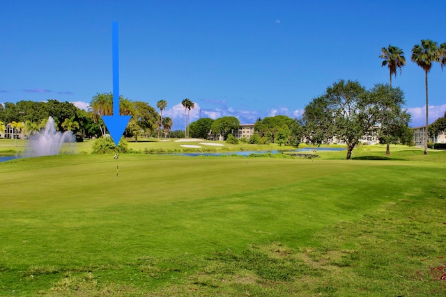 surrounding community with a water view and a yard