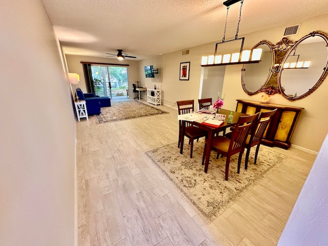 dining room featuring hardwood / wood-style floors, a textured ceiling, and ceiling fan