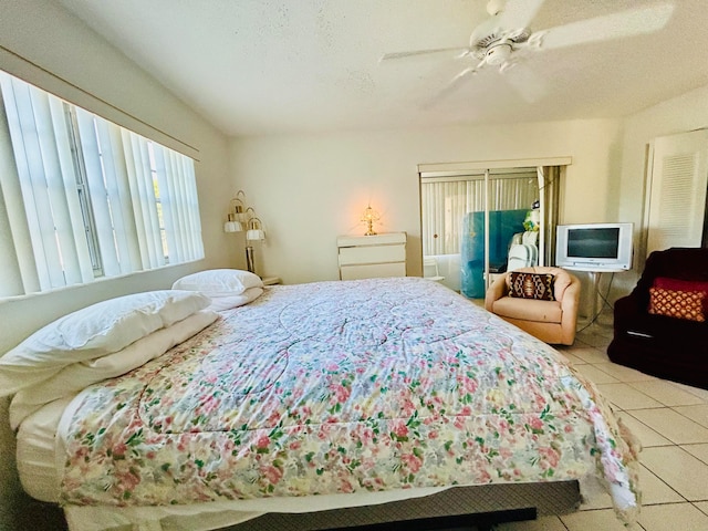 tiled bedroom featuring a textured ceiling and ceiling fan