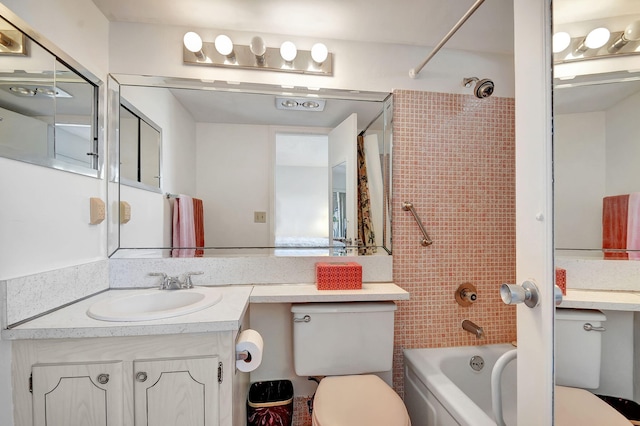 full bathroom with vanity, tiled shower / bath combo, and toilet