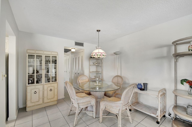 dining area with light tile patterned floors and a textured ceiling