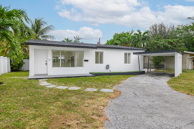 rear view of house featuring central air condition unit, a yard, and a carport