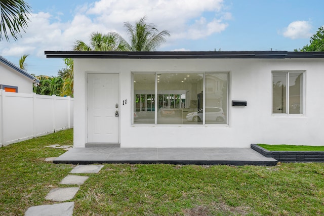 view of exterior entry with a lawn