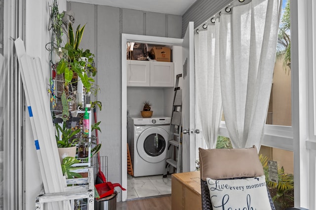 laundry area featuring cabinets, washer / clothes dryer, and light hardwood / wood-style flooring