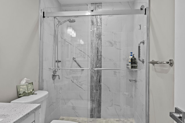 bathroom featuring vanity, toilet, and a shower with door