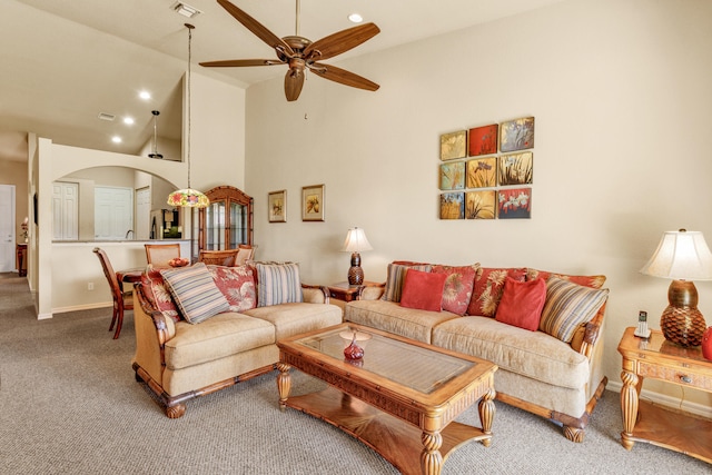 living room with ceiling fan, carpet floors, and high vaulted ceiling