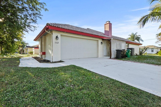 view of side of property featuring a garage and a lawn