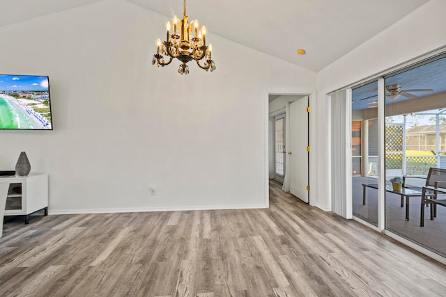 living room featuring ceiling fan with notable chandelier, light hardwood / wood-style floors, and vaulted ceiling