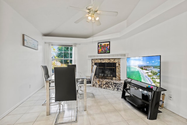 dining room with a premium fireplace, light tile patterned floors, ceiling fan, and vaulted ceiling