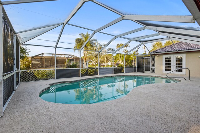 view of swimming pool with french doors, glass enclosure, and a patio area