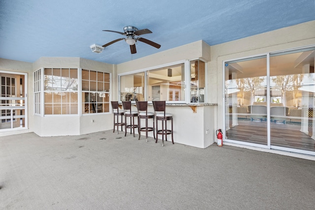 view of patio with a bar and ceiling fan