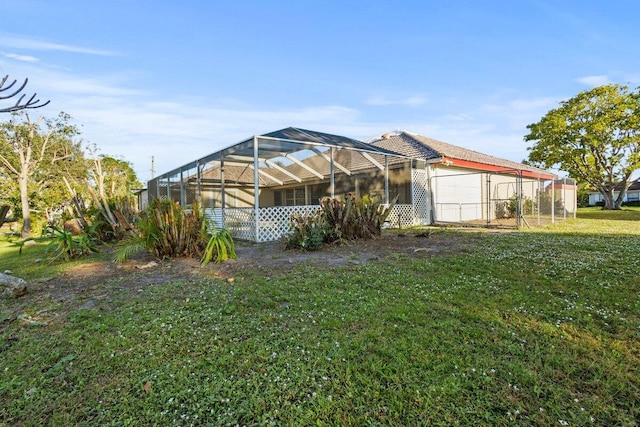 back of property with glass enclosure and a yard