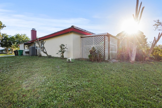 view of home's exterior with a yard and central AC