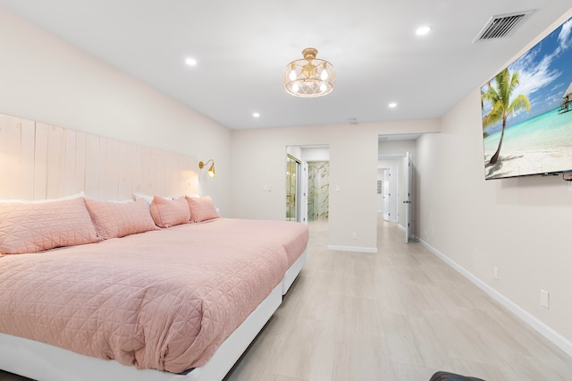 bedroom featuring ensuite bath and a notable chandelier