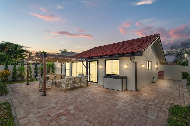 back house at dusk featuring an outdoor hangout area, a pergola, and a patio