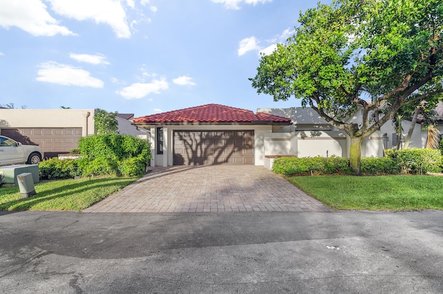 mediterranean / spanish house with a garage and a front lawn