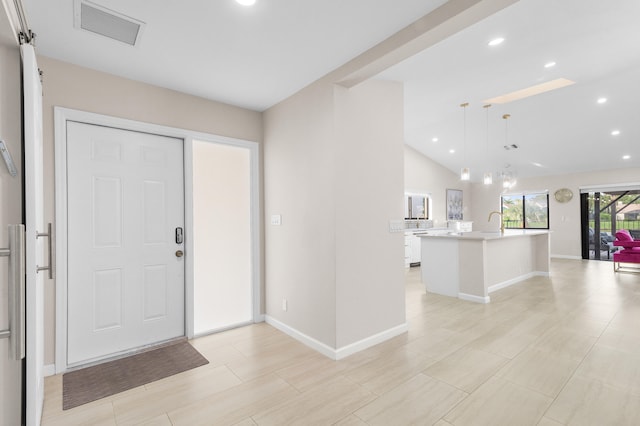 foyer with sink and vaulted ceiling