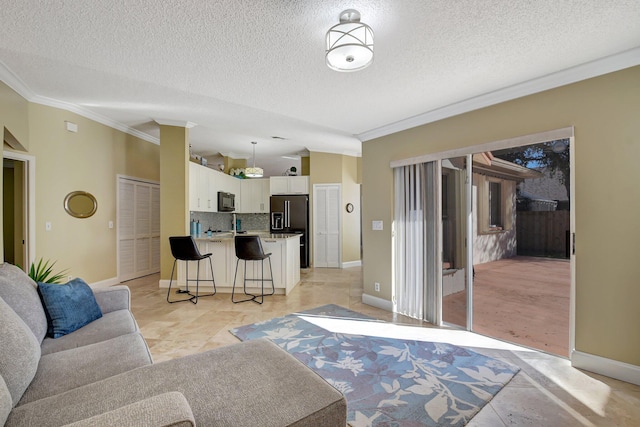 living room with light hardwood / wood-style floors, ornamental molding, and a textured ceiling