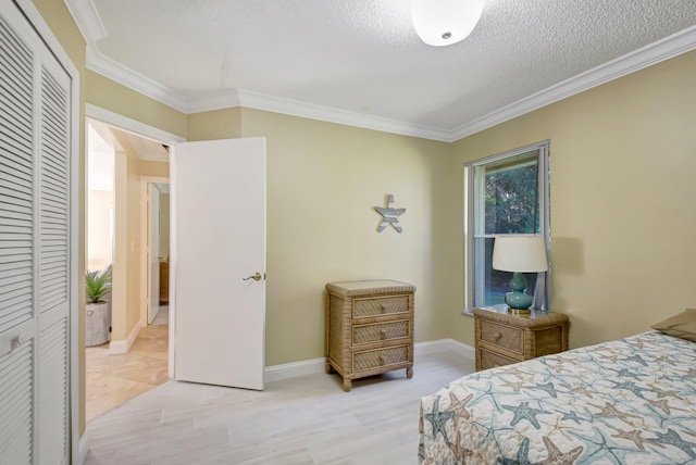 bedroom with crown molding, a closet, light hardwood / wood-style floors, and a textured ceiling