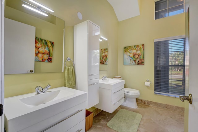 bathroom with toilet, vanity, and tile patterned floors