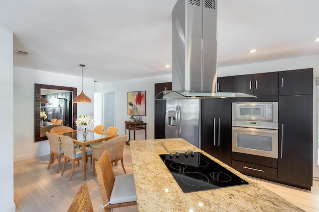 kitchen with island exhaust hood, pendant lighting, light wood-type flooring, and stainless steel appliances