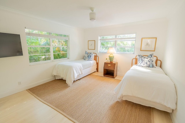 bedroom with hardwood / wood-style flooring, ceiling fan, and ornamental molding