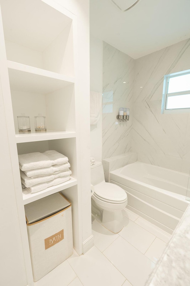 bathroom featuring tile patterned flooring, toilet, and tiled shower / bath