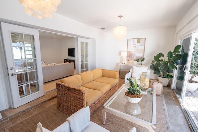 living room with french doors and a notable chandelier