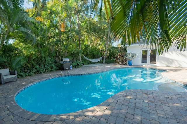 view of pool featuring a patio area and french doors