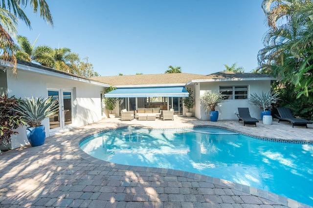 view of pool with outdoor lounge area, french doors, and a patio area