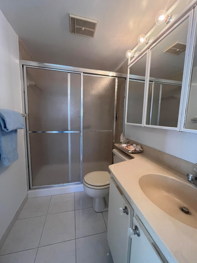 bathroom featuring tile patterned floors, vanity, toilet, and a shower with shower door