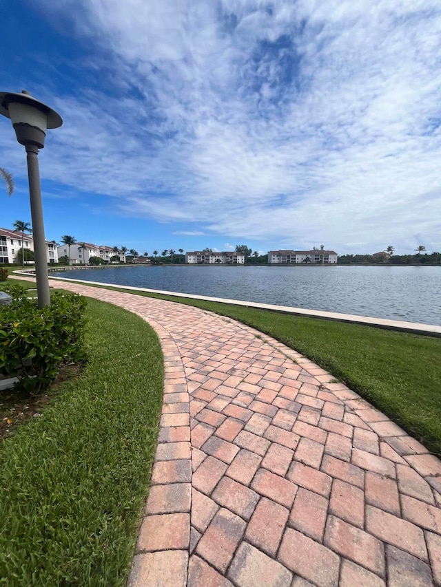 view of home's community with a lawn and a water view