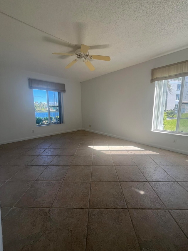 unfurnished room featuring ceiling fan and a textured ceiling