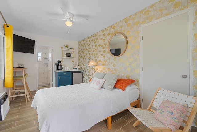 bedroom featuring ensuite bath, ceiling fan, and refrigerator