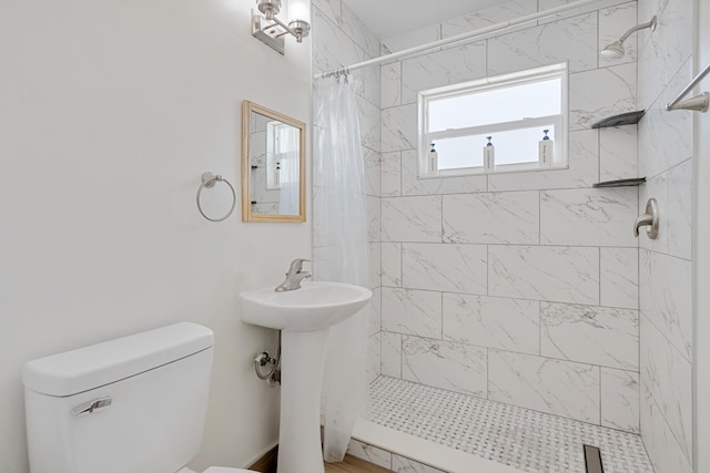 bathroom featuring curtained shower, toilet, and sink