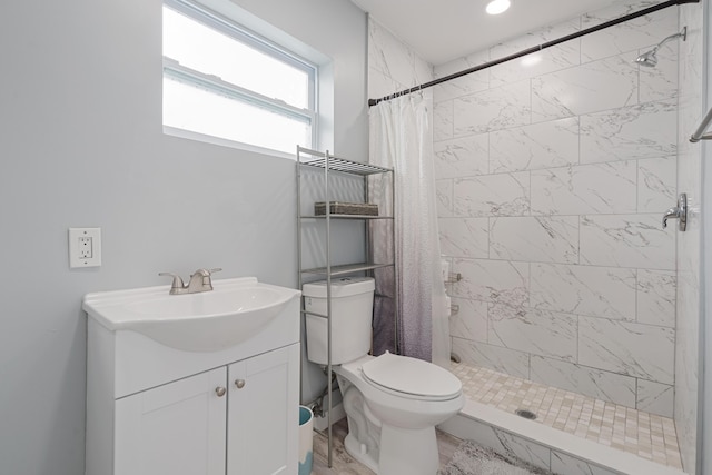 bathroom with toilet, vanity, and a shower with shower curtain