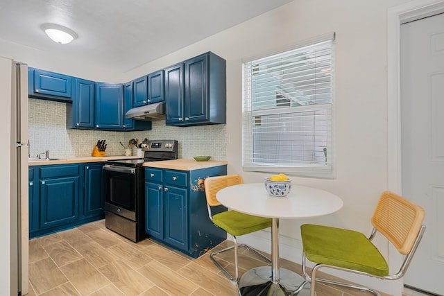 kitchen featuring stainless steel electric range, white refrigerator, blue cabinetry, and tasteful backsplash