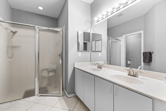 bathroom with walk in shower, vanity, and tile patterned floors