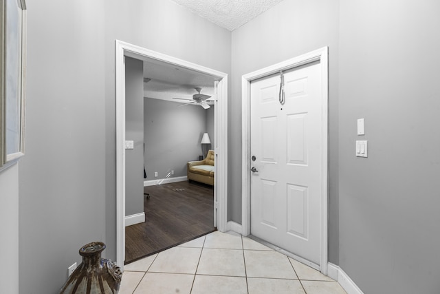 bathroom featuring a textured ceiling, ceiling fan, and tile patterned floors