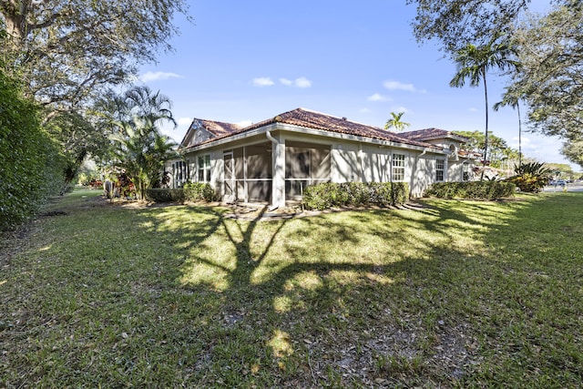 back of property featuring a yard and a sunroom