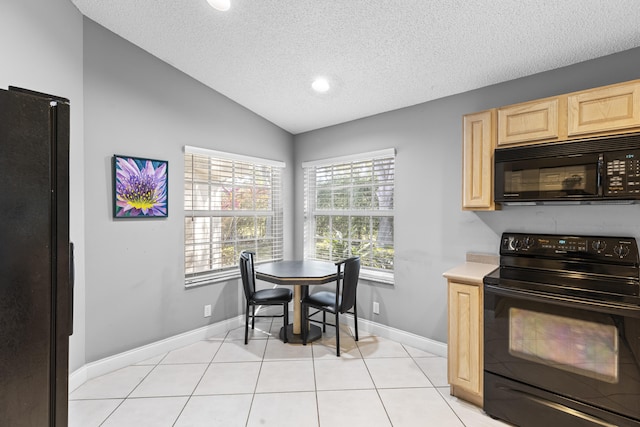 kitchen with a textured ceiling, vaulted ceiling, light brown cabinets, light tile patterned floors, and black appliances