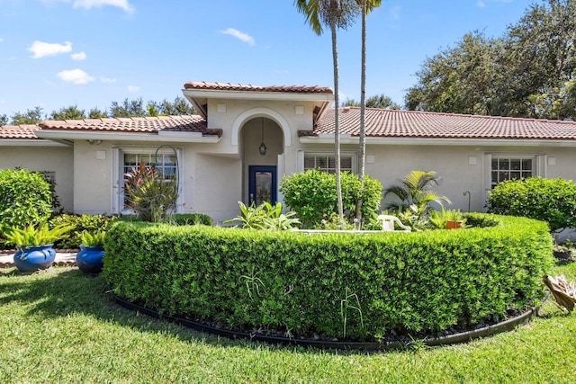 mediterranean / spanish-style home featuring a front lawn