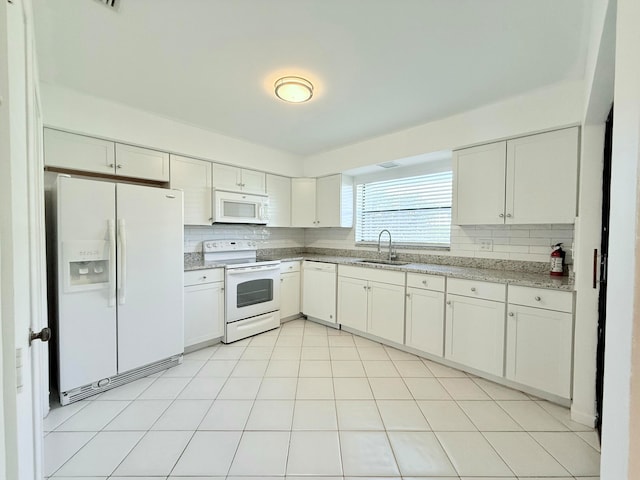 kitchen with white appliances, white cabinetry, and sink