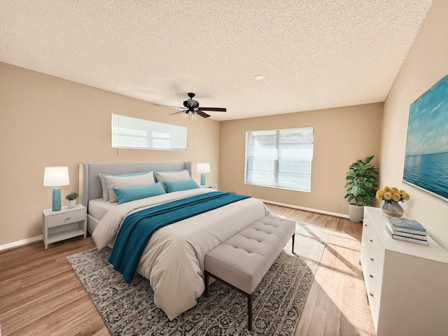 bedroom with ceiling fan, a textured ceiling, and light wood-type flooring