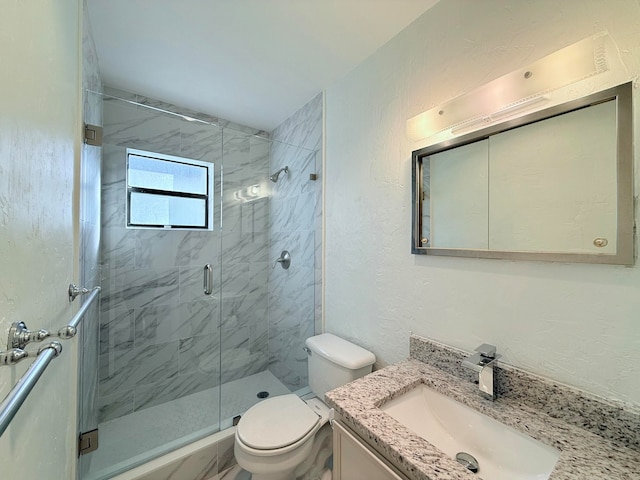 bathroom with an enclosed shower, vanity, and toilet