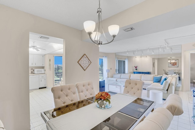 tiled dining area with ceiling fan with notable chandelier and track lighting