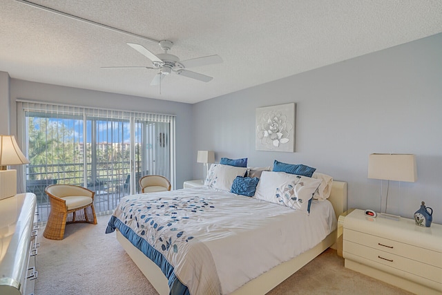 bedroom with ceiling fan, access to outside, a textured ceiling, and light carpet