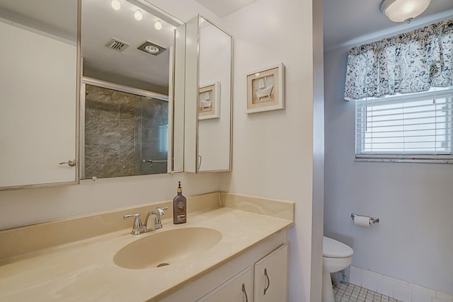 bathroom featuring tile patterned floors, vanity, an enclosed shower, and toilet